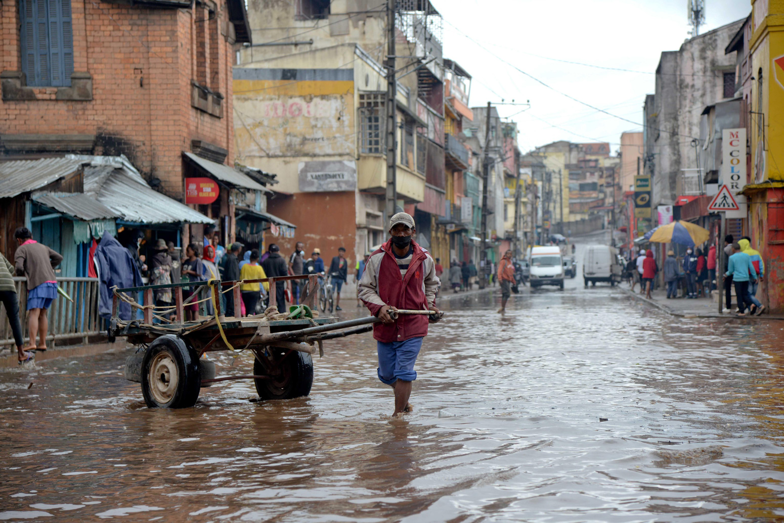 A man wades through a flooded road in Madagascar, after tropical cyclone Batsirai, Feb 2022