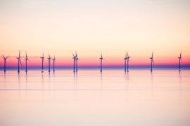 Wind power stations at sea in evening