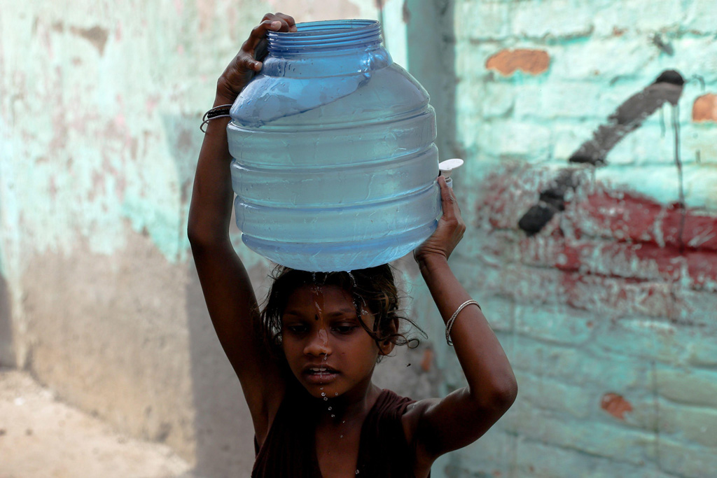 A girl carries water during May 2022 heatwave in New Delhi, India
