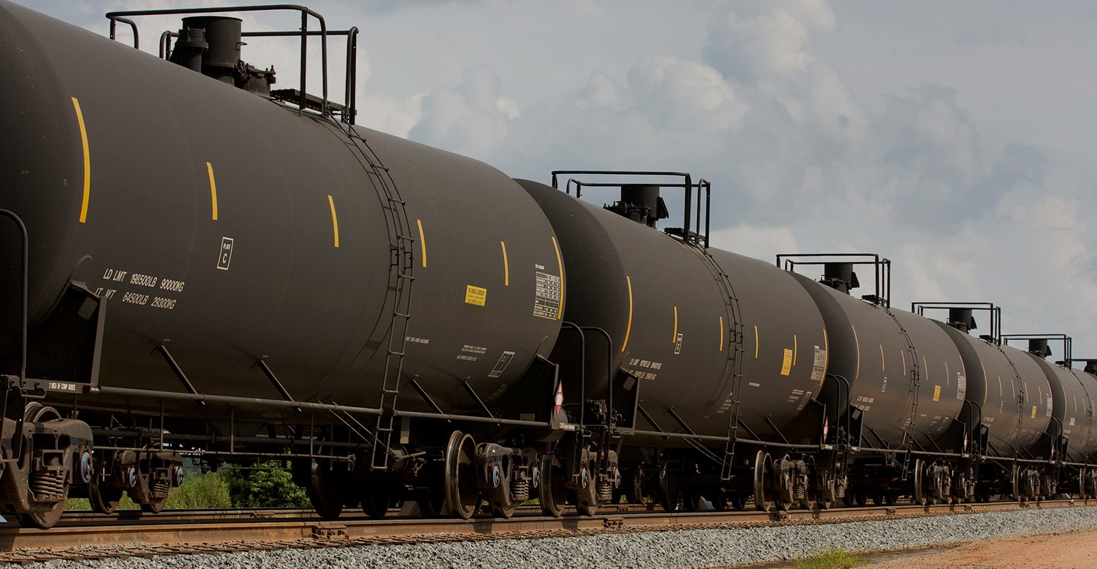 Railroad train of tanker cars transporting crude oil on the tracks.