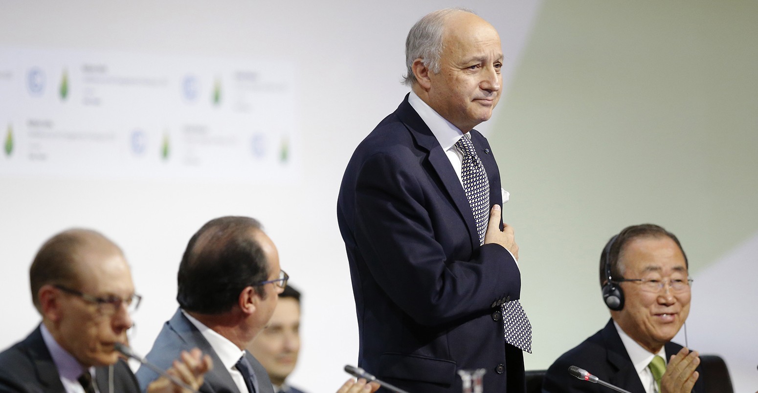 Laurent Fabius, puts his hand over his heart after his speech as he stands near Francois Hollande, and Ban Ki-moon at the World Climate Change Conference 2015 (COP21) at Le Bourget, near Paris, France