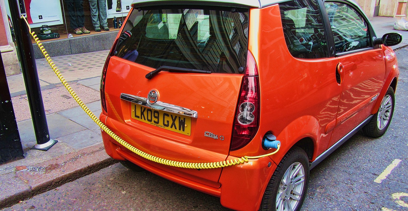 Orange electric car on charge, London, England, UK
