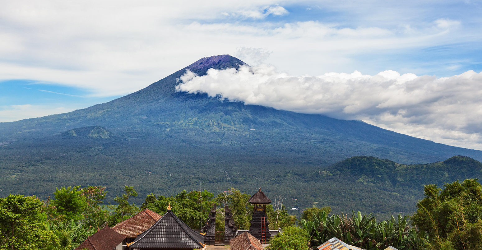 K9NHH6 View from Lempuyang mountain to traditional Balinese temple on Mount Agung slopes background. Mount Agung is highest active volcano on Bali island.
