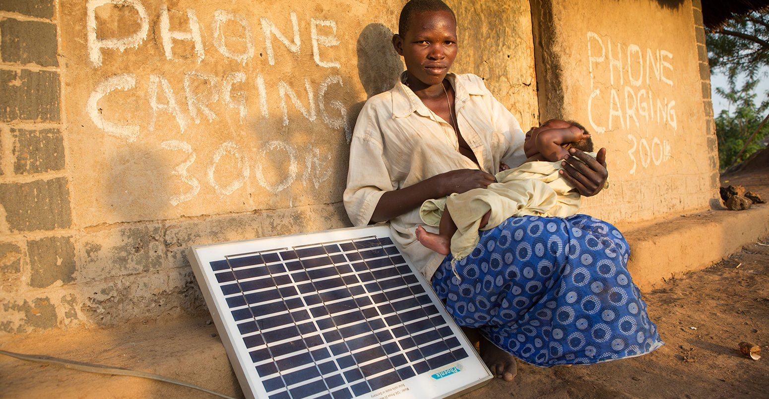 D7A75P Mother with a solar panel in Lira District, Uganda, East Africa.