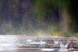 C5T9H7 Raindrops hitting a picnic table; Cornwall;UK.