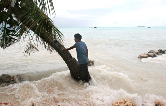 King tides flood property on Kiribati atoll. Credit: Jeremy Sutton-Hibbert / Alamy Stock Photo. BGP1PD