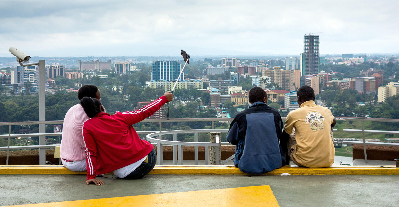 Teenagers taking a selfie looking out over the city in Nairobi, Kenya. Credit: Hugh Mitton / Alamy Stock Photo. G23XN7