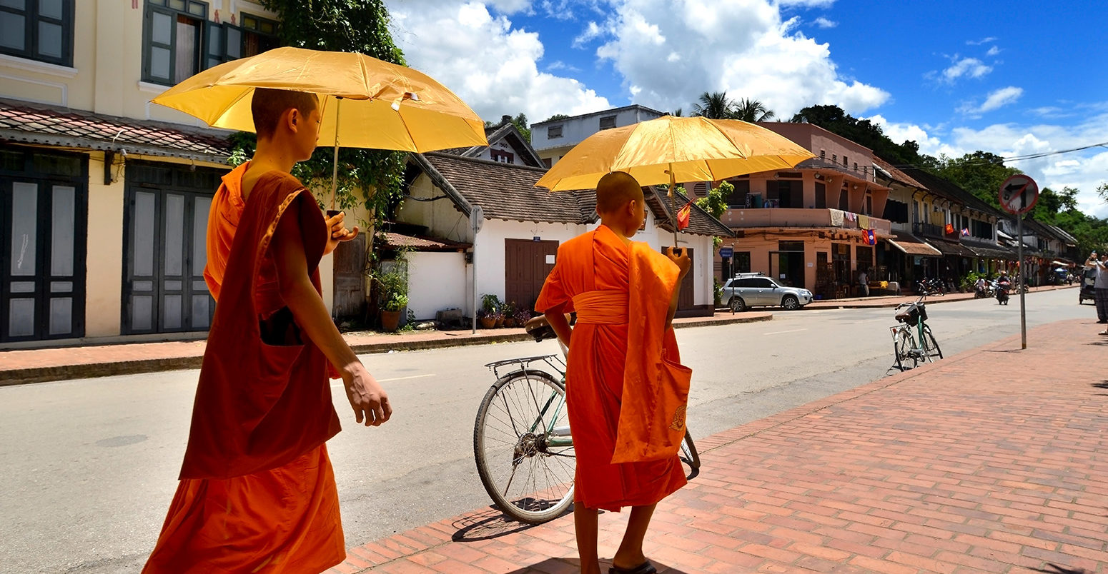 Two monks shading from the sun in Loungprabang, Laos. Credit: Nopadol Uengbunchoo / Alamy Stock Photo. HWPG36