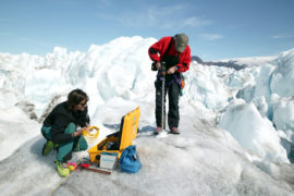 Glaciologists measuring the rate of movement on the Kangerdlussuaq glacier, Greenland. Credit: Steve Morgan / Alamy Stock Photo. DFB4EE