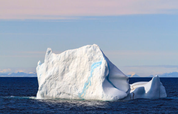 Iceberg floating in ocean water of Smith Sound in the high arctic of Nunavut, Canada, mid summer.