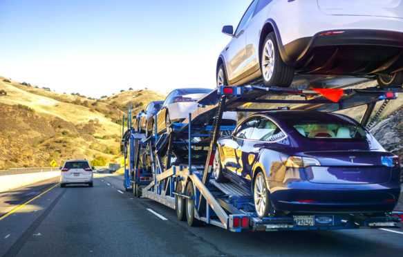汽车运输车在加利福尼亚州的高速公路上携带新的特斯拉3型车。图片来源：Andrei Stanescu / Alamy股票照片。R6HR26