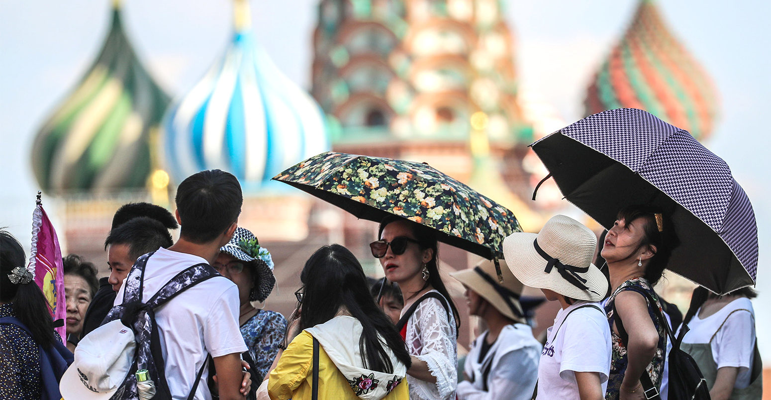 人们shelter under umbrellas during a heatwave in Moscow, 3 August 2018. Credit: ITAR-TASS News Agency / Alamy Stock Photo.