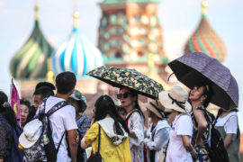 People take shelter under umbrellas during a heatwave in Moscow, 3 August 2018. Credit: ITAR-TASS News Agency / Alamy Stock Photo.