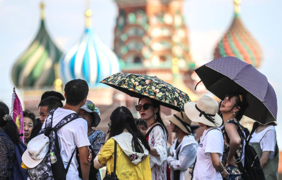 人们在2018年8月3日在莫斯科的热浪期间在雨伞下庇护。信贷：ITAR-TASS新闻社 / Alamy Stock Photo。