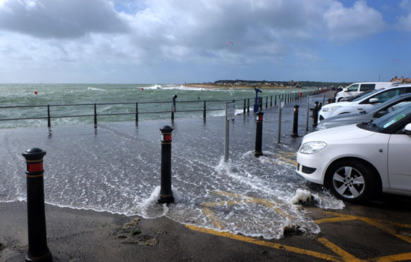 沿海洪水进入英国多塞特郡莫德福德码头的停车场和人行道。学分：海伦·詹姆斯 /阿拉米股票照片