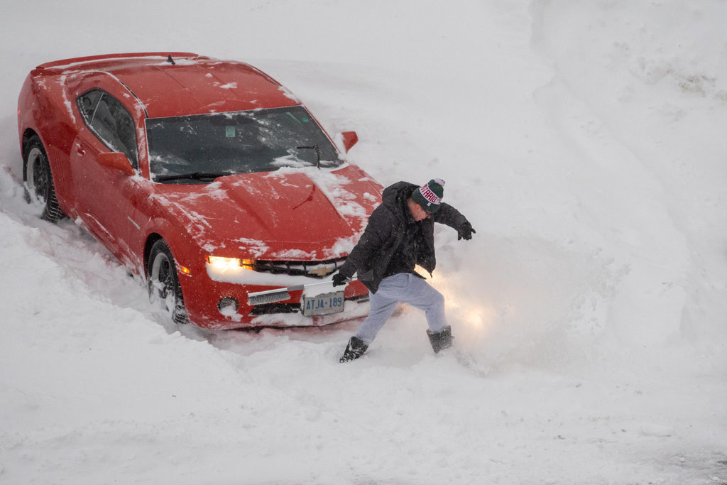 Toronto, Canada. 29th Jan 2019. A man digs out a red Chevrolet car from the parking lot snow in the morning
