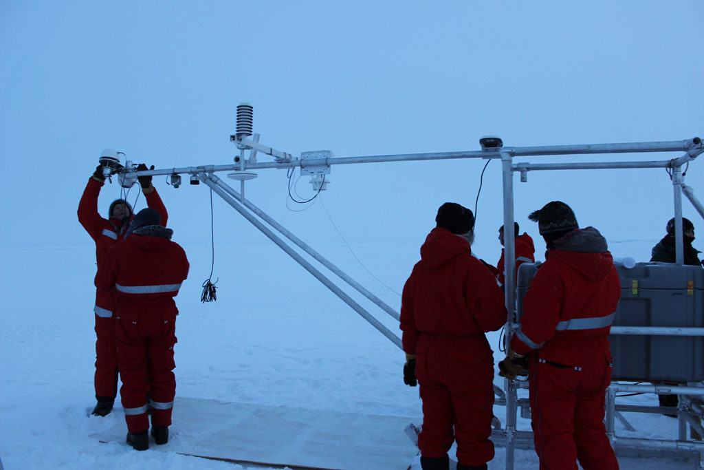 Dr Ola Perrson and other MOSAiC scientists set up a scientific instrument in the Central Arctic Ocean. Credit: Daisy Dunne for Carbon Brief