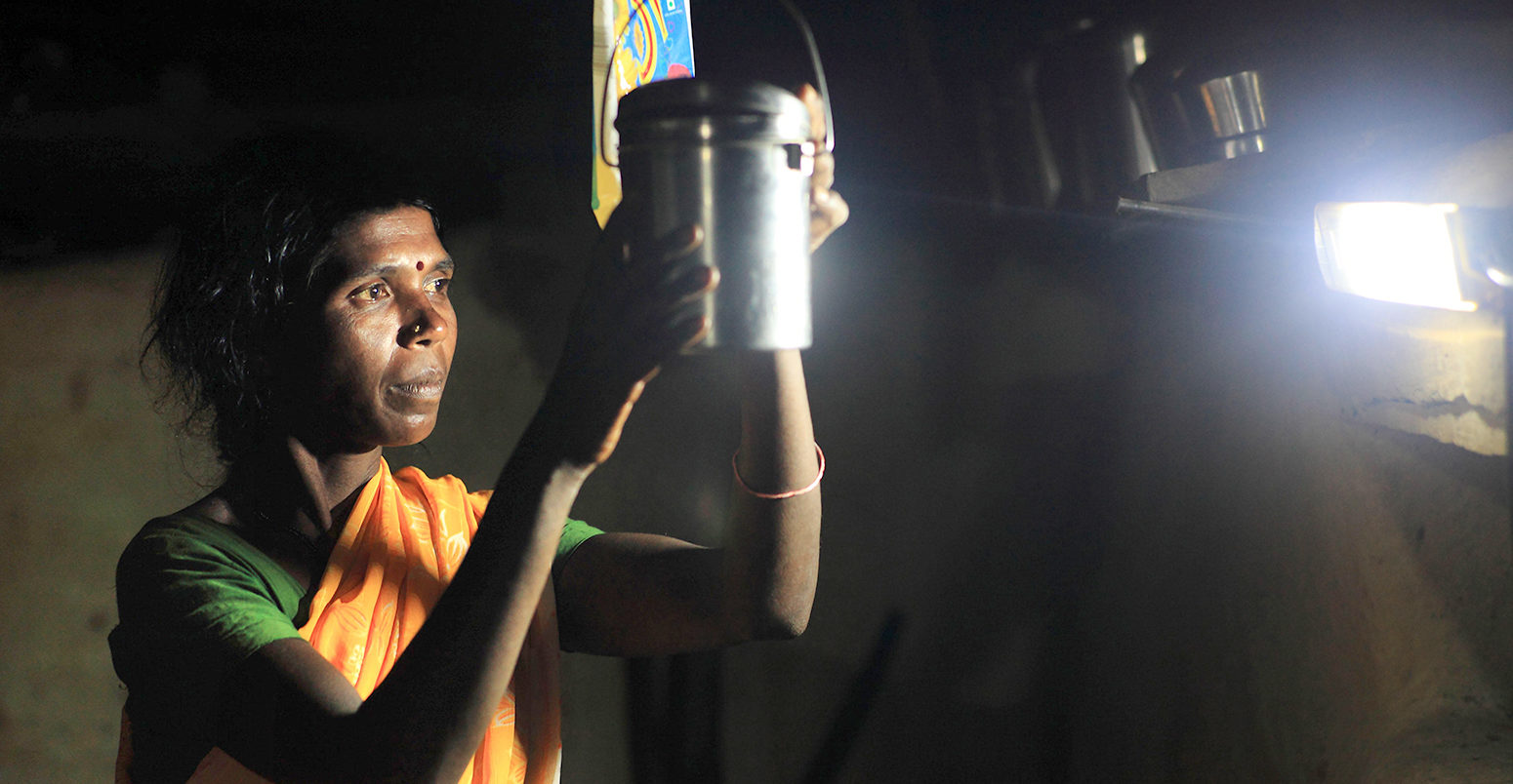 LED bulbs illuminate a woman as she does housework at night, Karnataka, India. Credit: ZUMA Press, Inc. / Alamy Stock Photo. D9RYDR