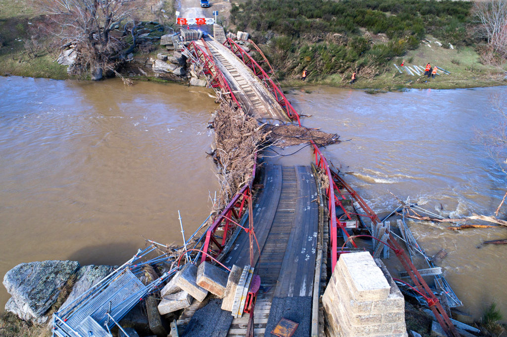 Destroyed suspension bridge over Taieri River, Otago, New Zealand during floods in 2017. Credit: David Wall / Alamy Stock Photo.