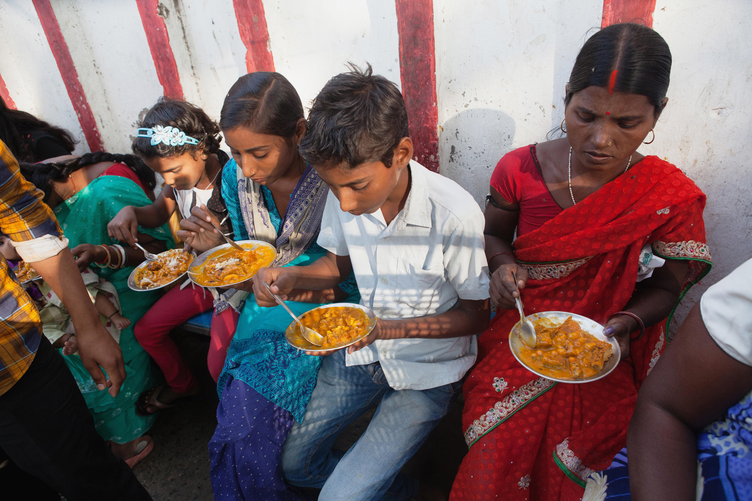 A family eating vegetarian street food in Bodh Gaya, India.