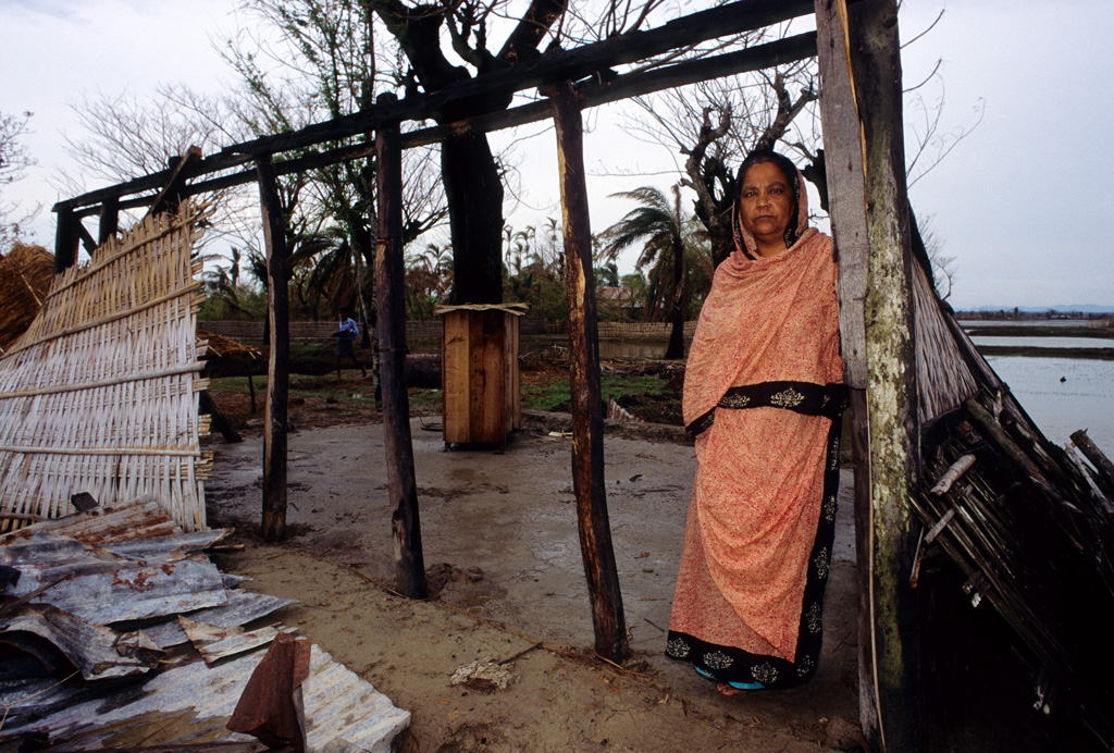 A-woman-stands-at-the-wreckage-of-her-home,-in-Banshkhali-Bangladesh