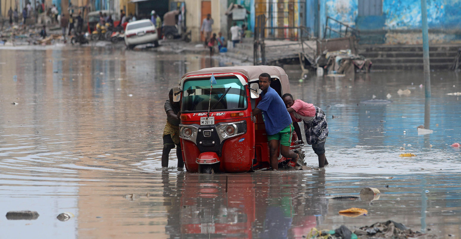 Somali-men-push-their-rickshaw-through-flood-waters-after-a-flash-flood-in-Mogadishu,-Somalia