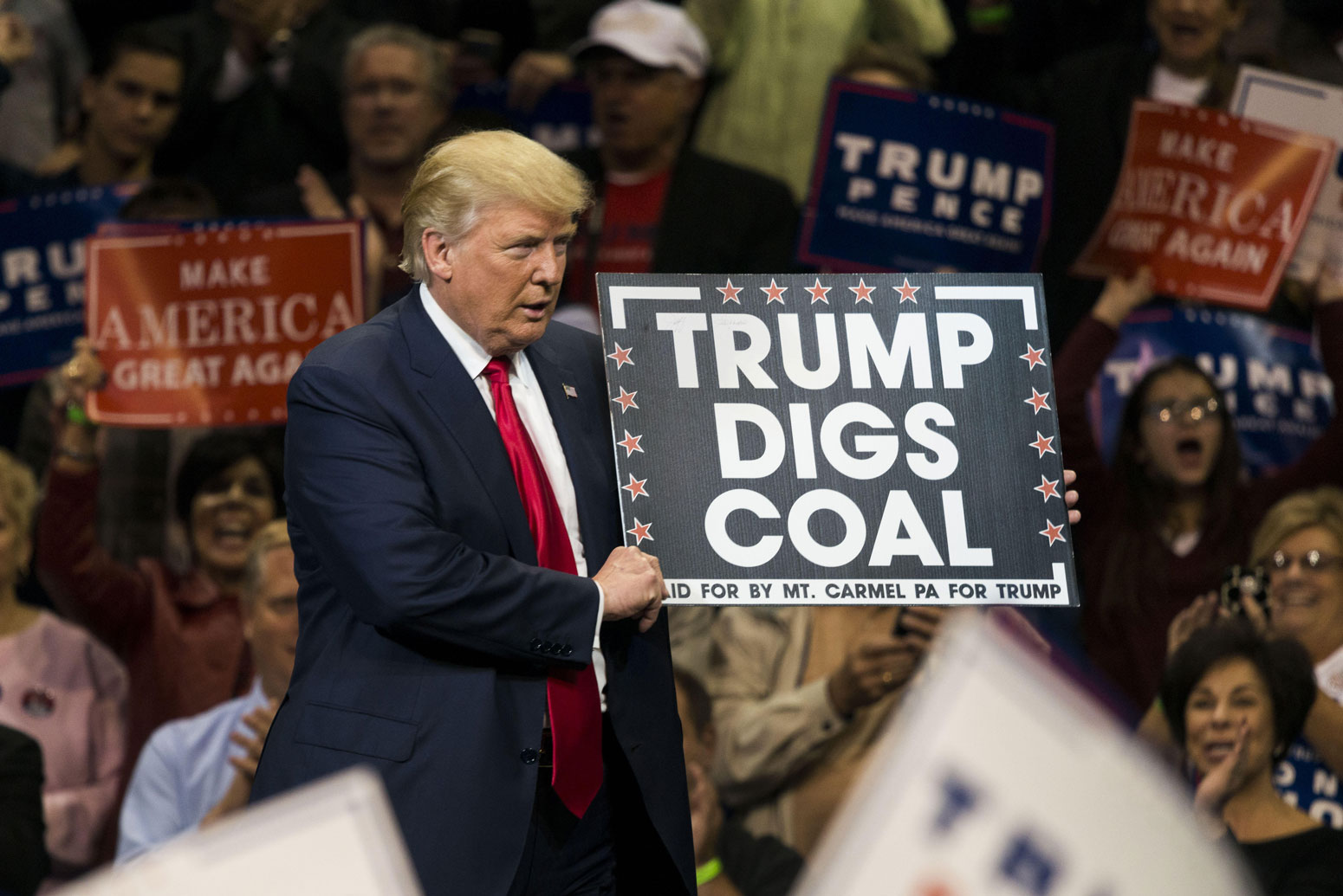 唐纳德·特朗普在宾夕法尼亚州的一场集会上举着“特朗普挖煤”的标语