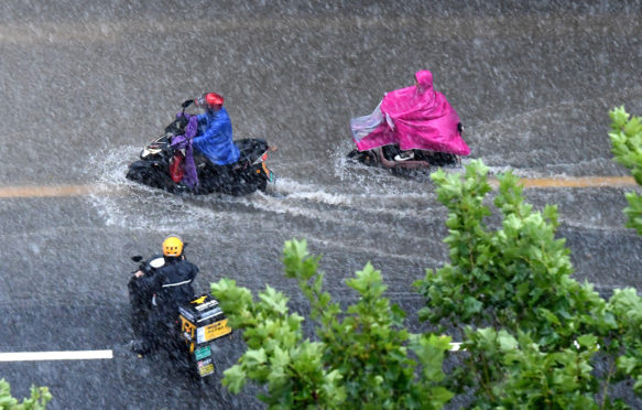 人们骑着雨水雨后骑着郑州的一条水道道路