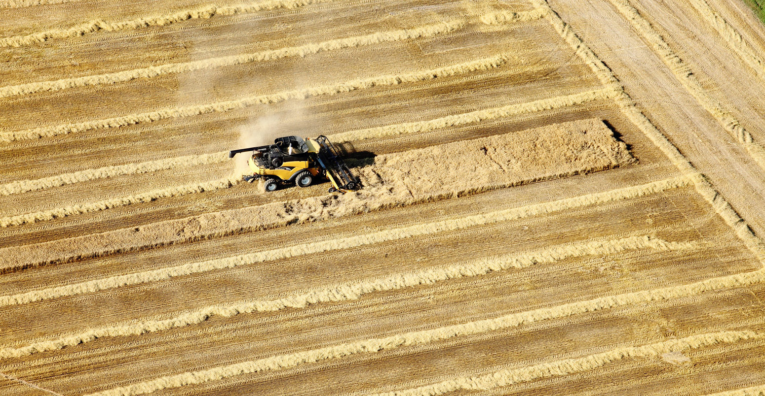 An aerial view of farm machinery in the field harvesting wheat Idaho_EN9MDW