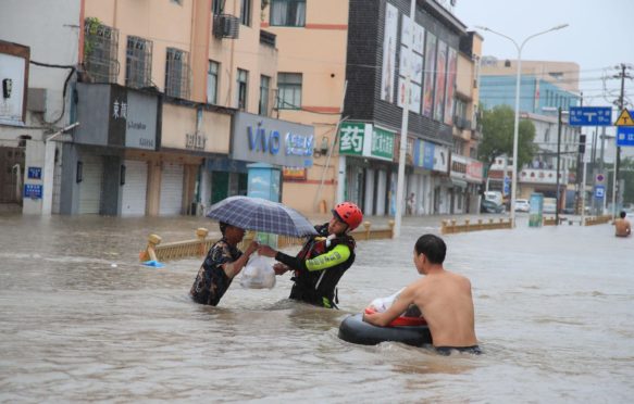 台风fa给宁波市带来暴雨和洪水，消防队员帮助市民运送车辆并确保安全