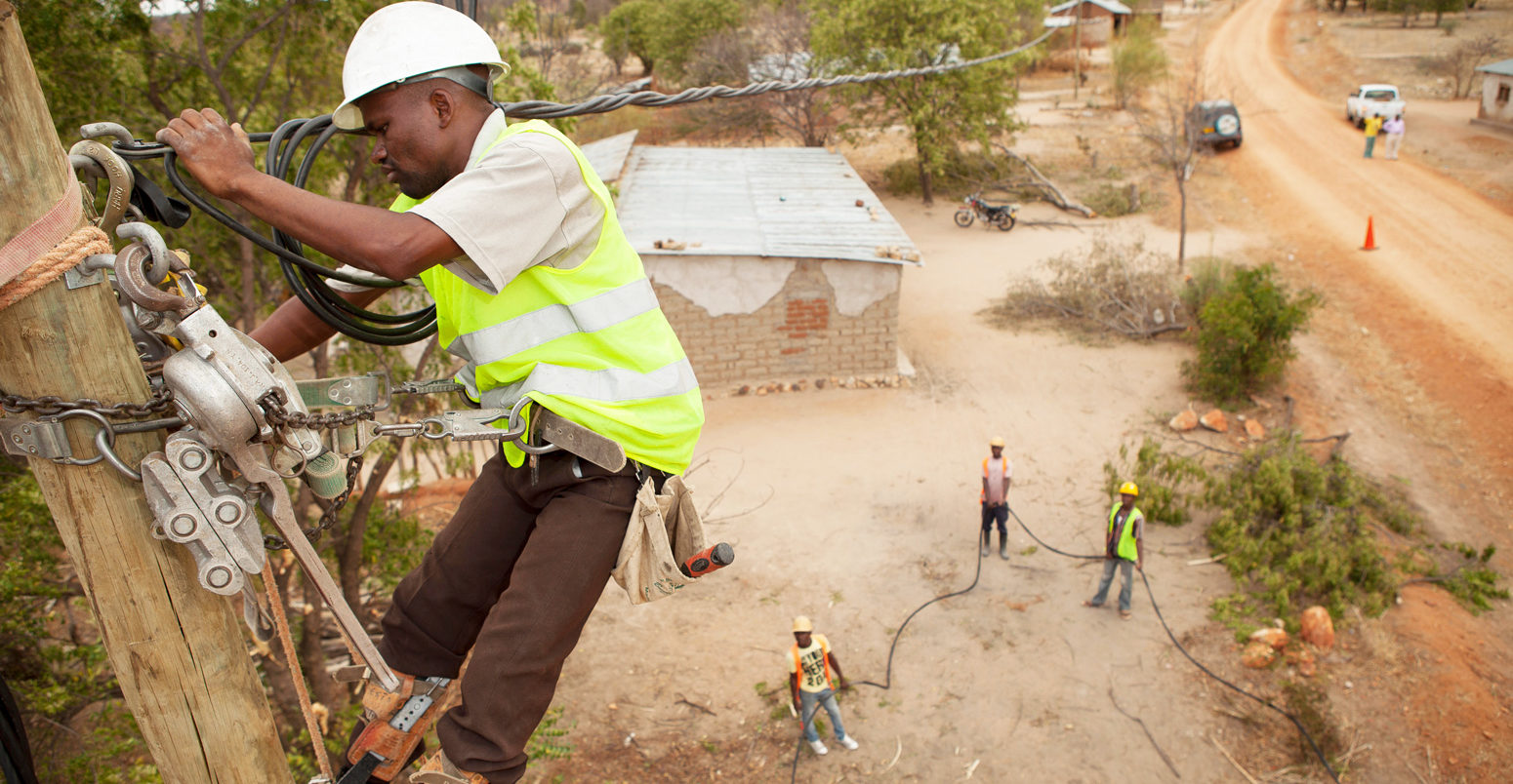 Workers-string-new-power-cables-in-a-rural-village-near-Dodoma,-Tanzania,-East-Africa-Image ID: FA4P68