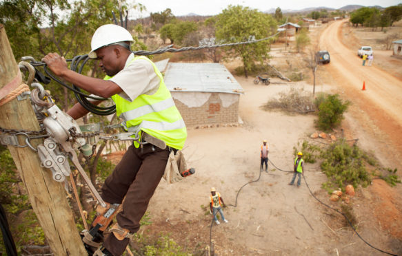 Workers-string-new-power-cables-in-a-rural-village-near-Dodoma，坦桑尼亚，东非图片ID:FA4P68