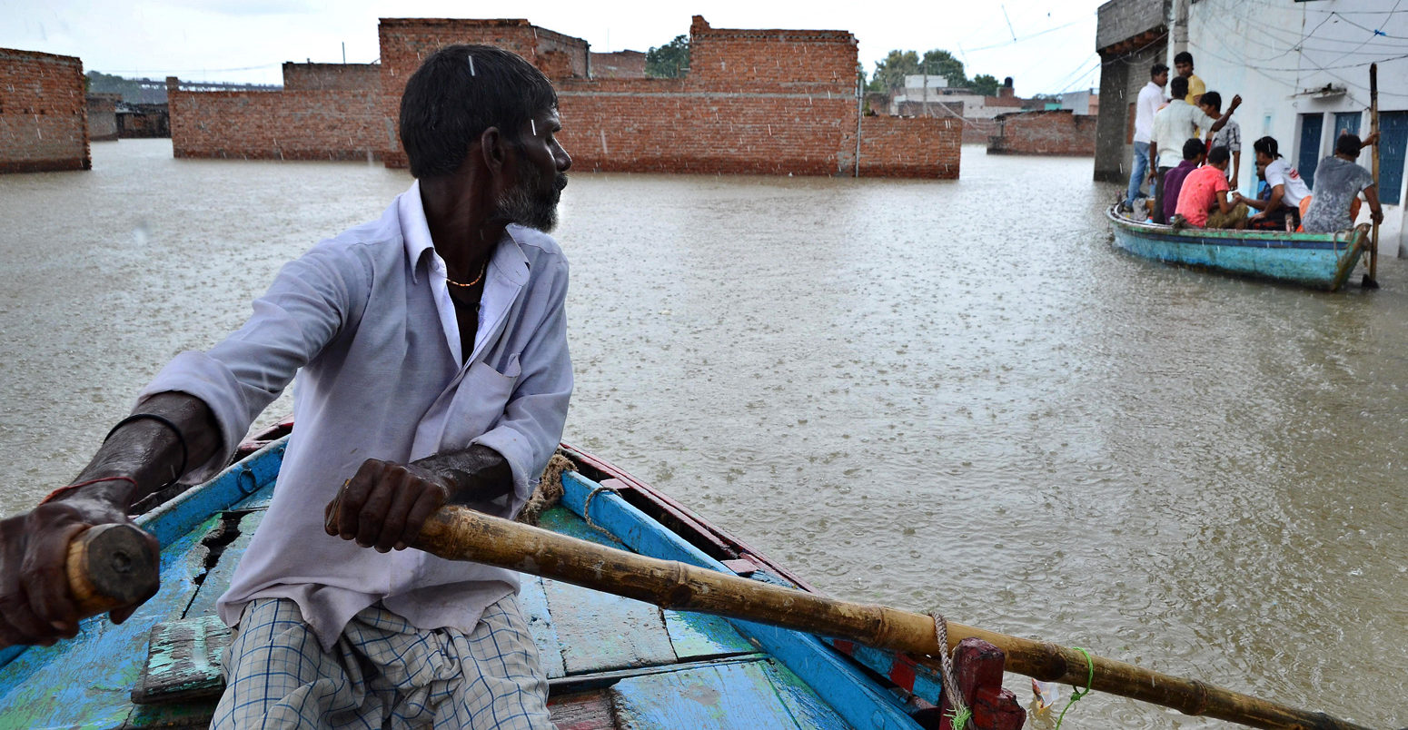 在印度瓦拉纳西被洪水淹没的村庄里，一名男子在划船
