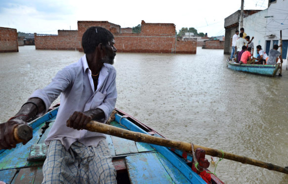 在印度瓦拉纳西被洪水淹没的村庄里，一名男子在划船