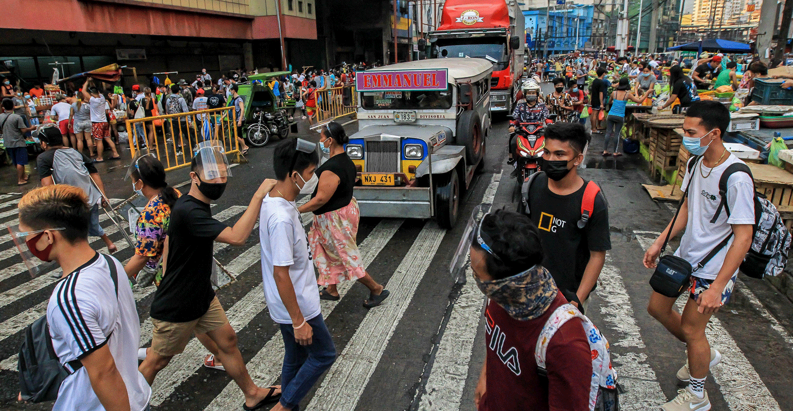 2021年3月，在马尼拉一条繁忙的街道上，人们戴着防护面具