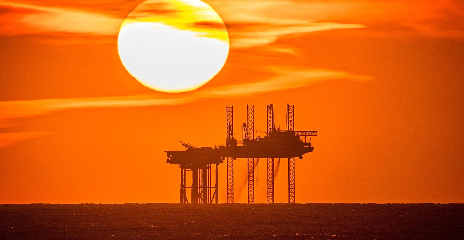 Sunset pours into the horizon behind the Hamilton Oil Rig off the Southport coastline, UK