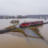 Train-passing-through-a-flooded-road-in-Germany,-February-2021