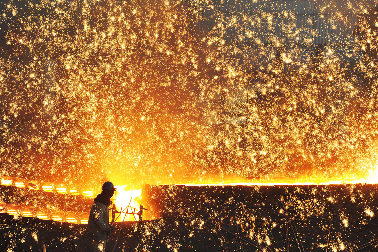 A spark shower in front of a blast furnace at a steel plant in Dali, China