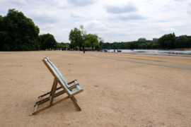 Scorched grass and empty deck chairs in Hyde Park, London, UK, during the heatwave in July 2022. Credit: Matthew Chattle / Alamy Stock Photo.
