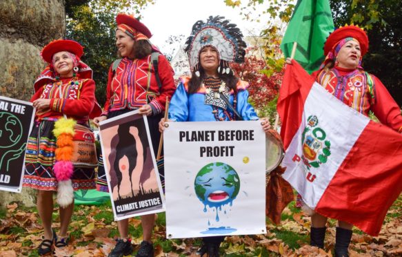 Indigenous protesters hold placards during a march in London