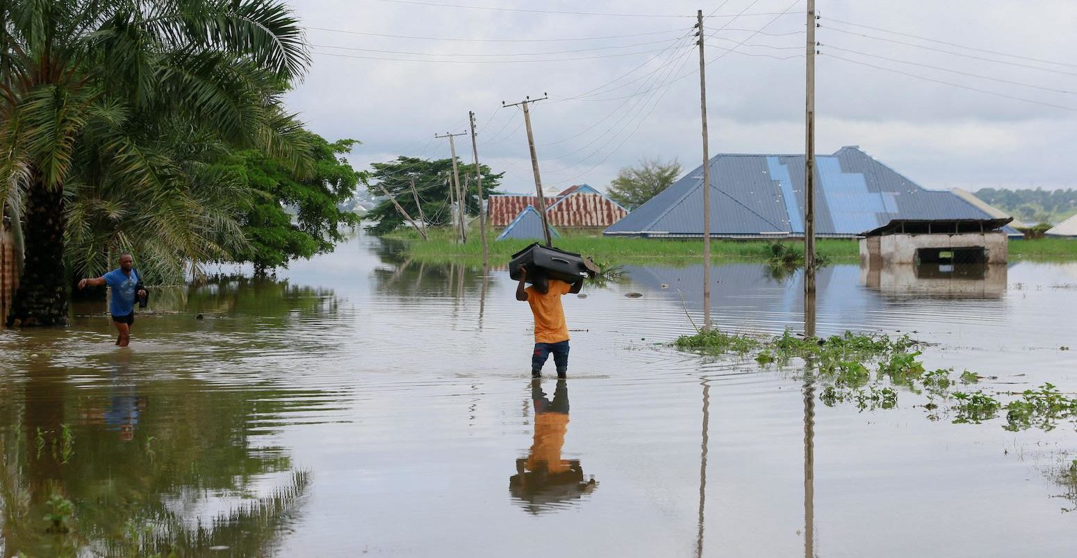 A man wades through flood water in Nigeria.