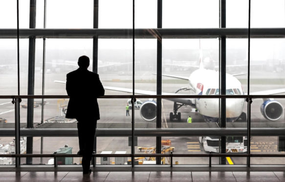 Silhouette of a passenger waiting for a plane at Heathrow airport, London, UK.