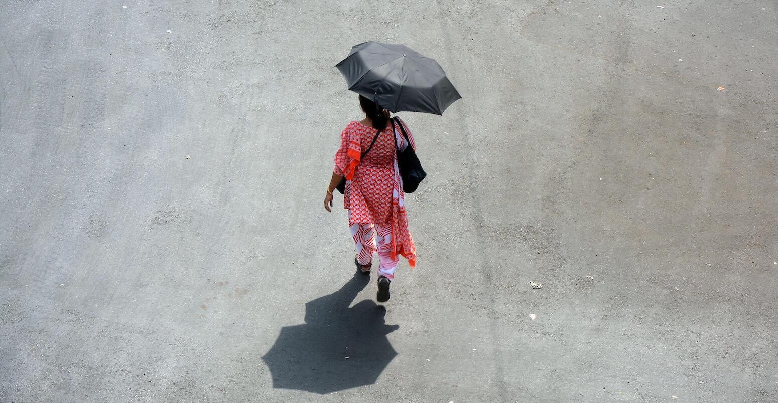 A woman comes outside holding an umbrella in a hot summer day in Kolkata, India on April 26, 2022.