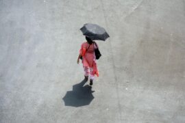 A woman comes outside holding an umbrella in a hot summer day in Kolkata, India on April 26, 2022.