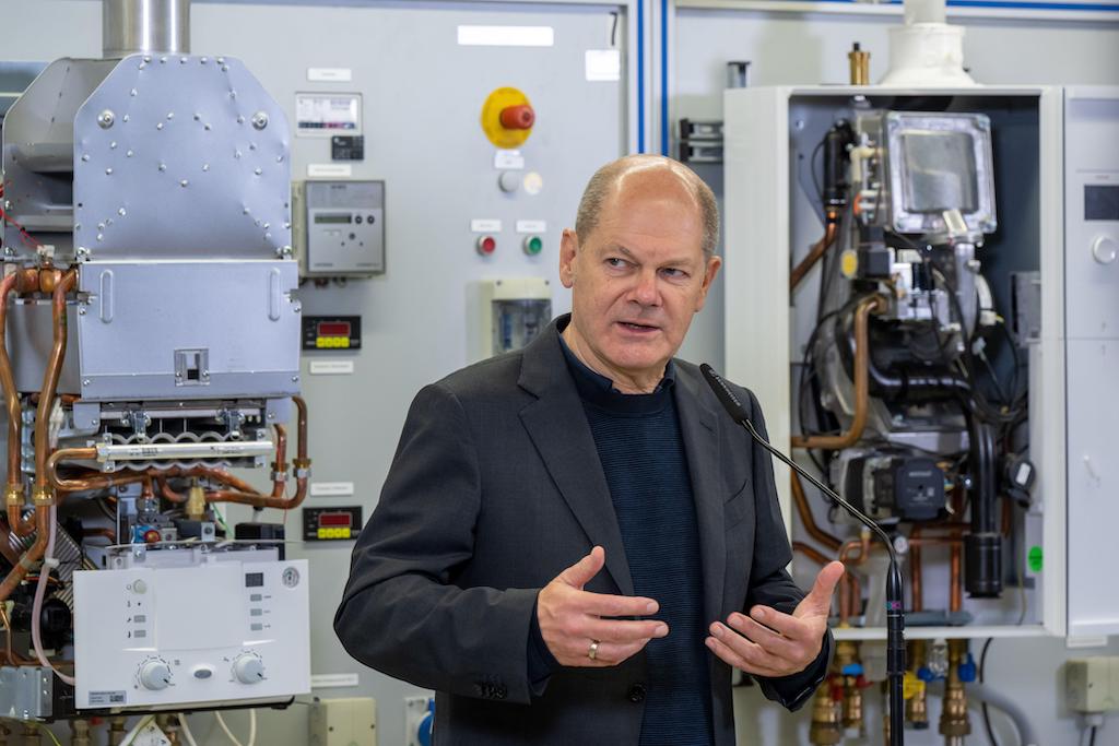 German Chancellor Olaf Scholz makes a statement at an assembly wall on which various heating burners are installed for training purposes during his visit to the Chamber of Crafts' training center on October 22, 2022.