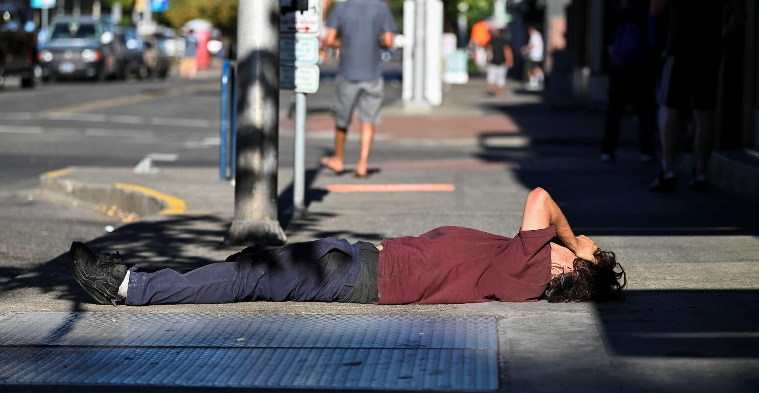 一个人我ies on a sidewalk during a heatwave in Portland, Oregon, U.S, on 11 August 2021.