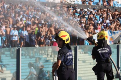 Firefighters spray water at people due to intense heat during a football game in Argentina.