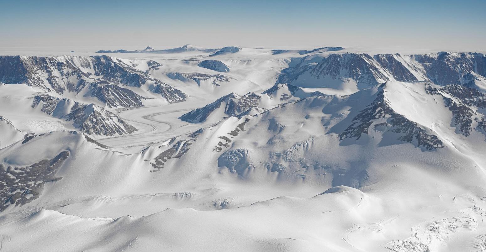 An aerial view of white mountains in Antarctica.